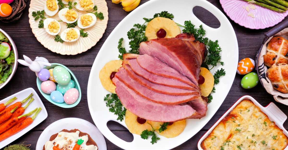 top down view of Easter ham, deviled eggs, carrots, pasta, and more items