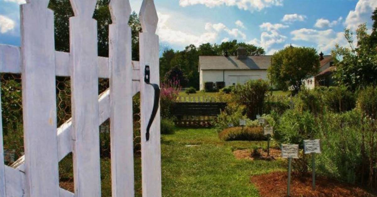 white fence door and view of a white house in the back