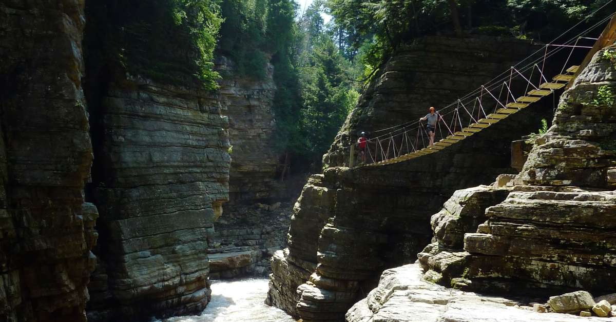 river with cliffs on both sides with a walkway and people on it