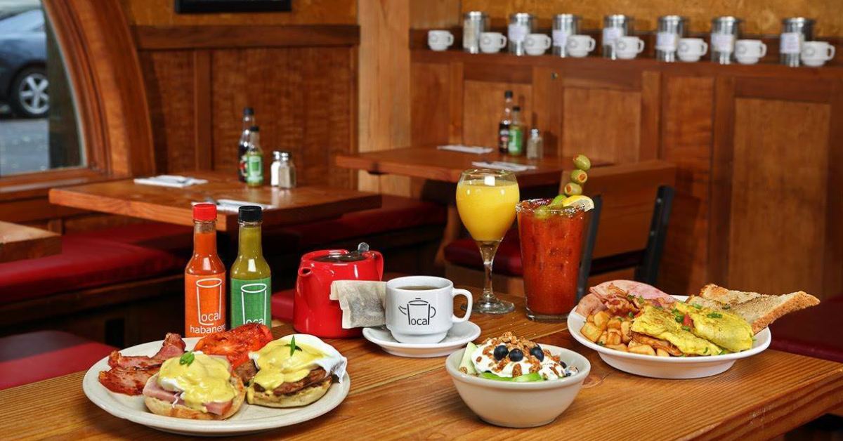 tea, mimosa, bloody mary, coffee, hot sauces, and breakfast foods on a table