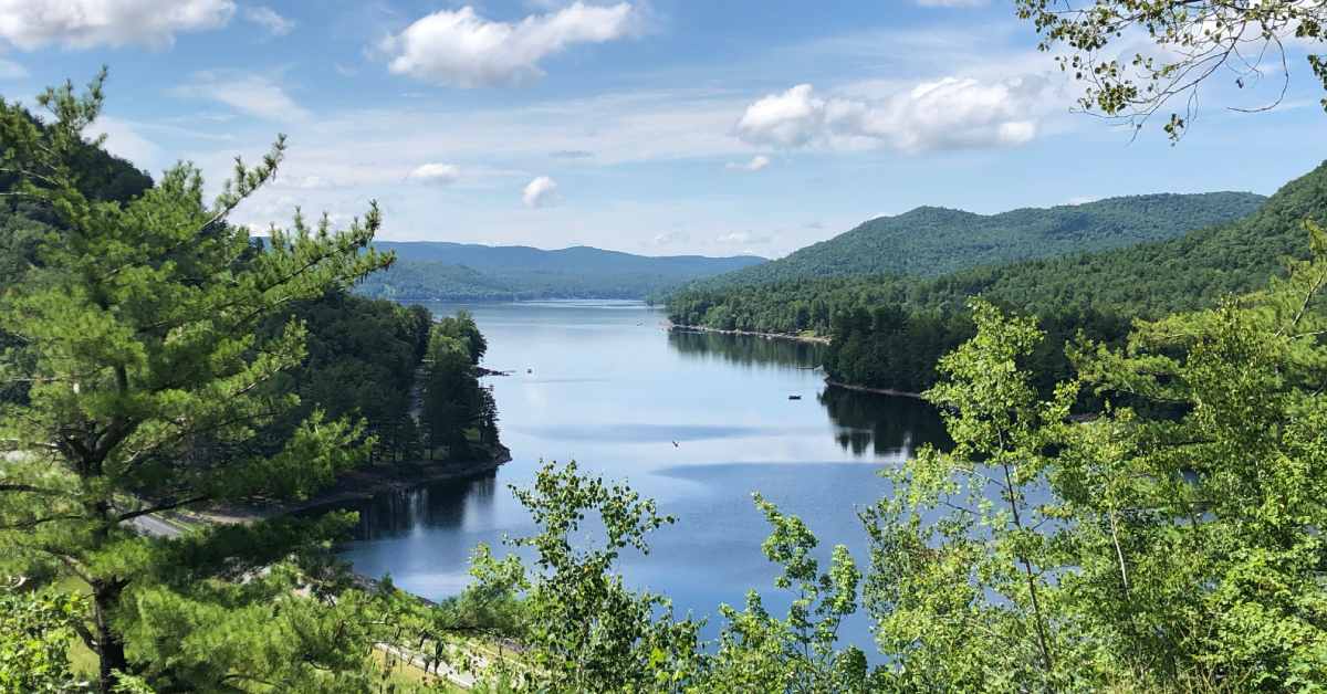 view of a lake and mountains from the top of a mountain