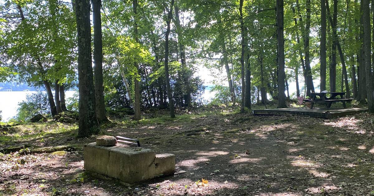 campsite near water, picnic table, fire pit