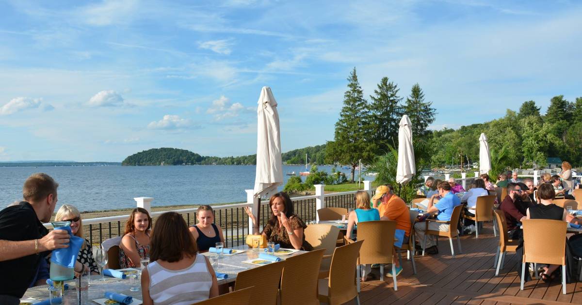 people dining on a patio by the lake