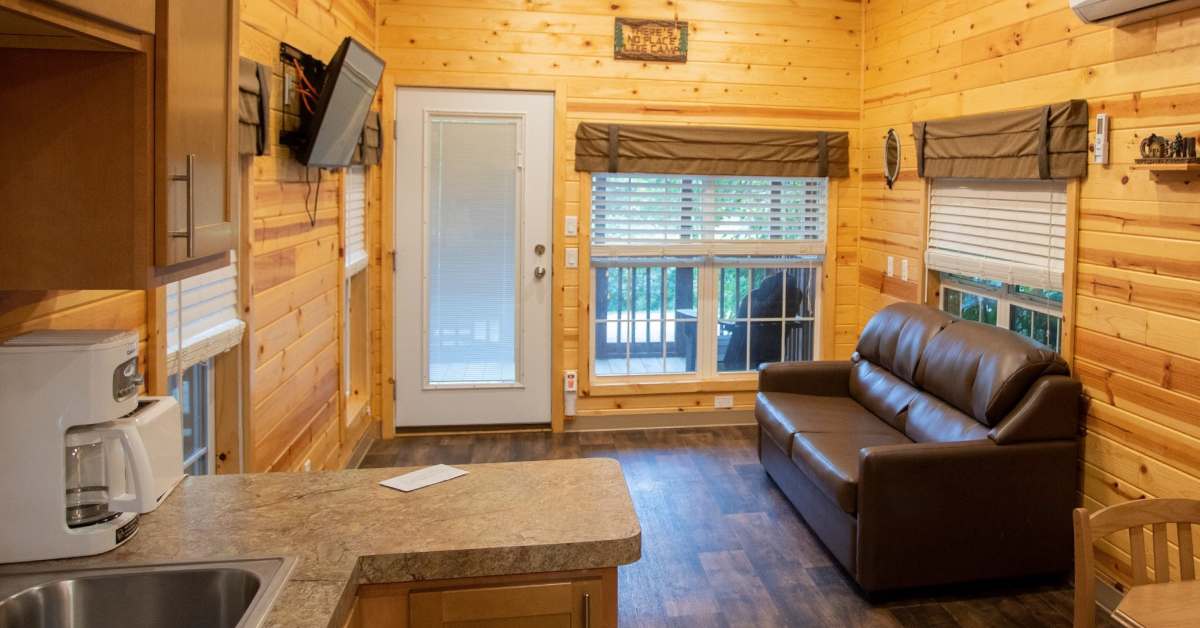 inside cabin with couch, kitchen counter, tv