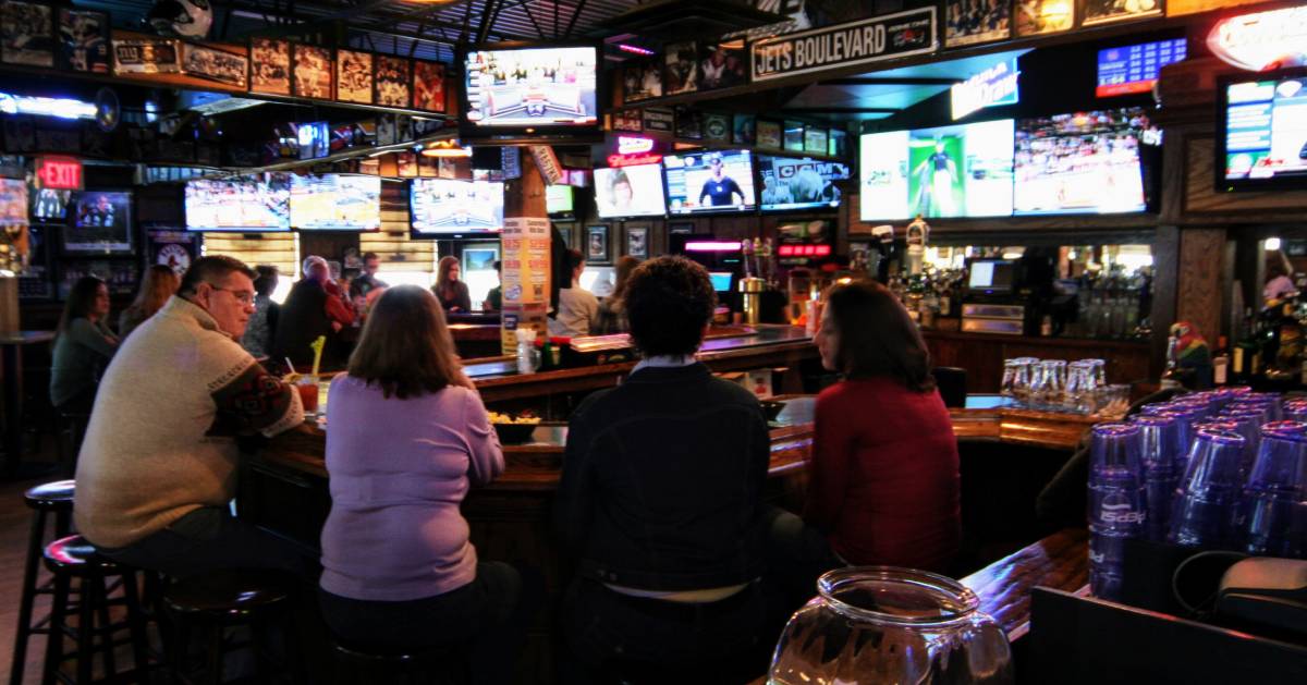 people sitting at a bar in a pub