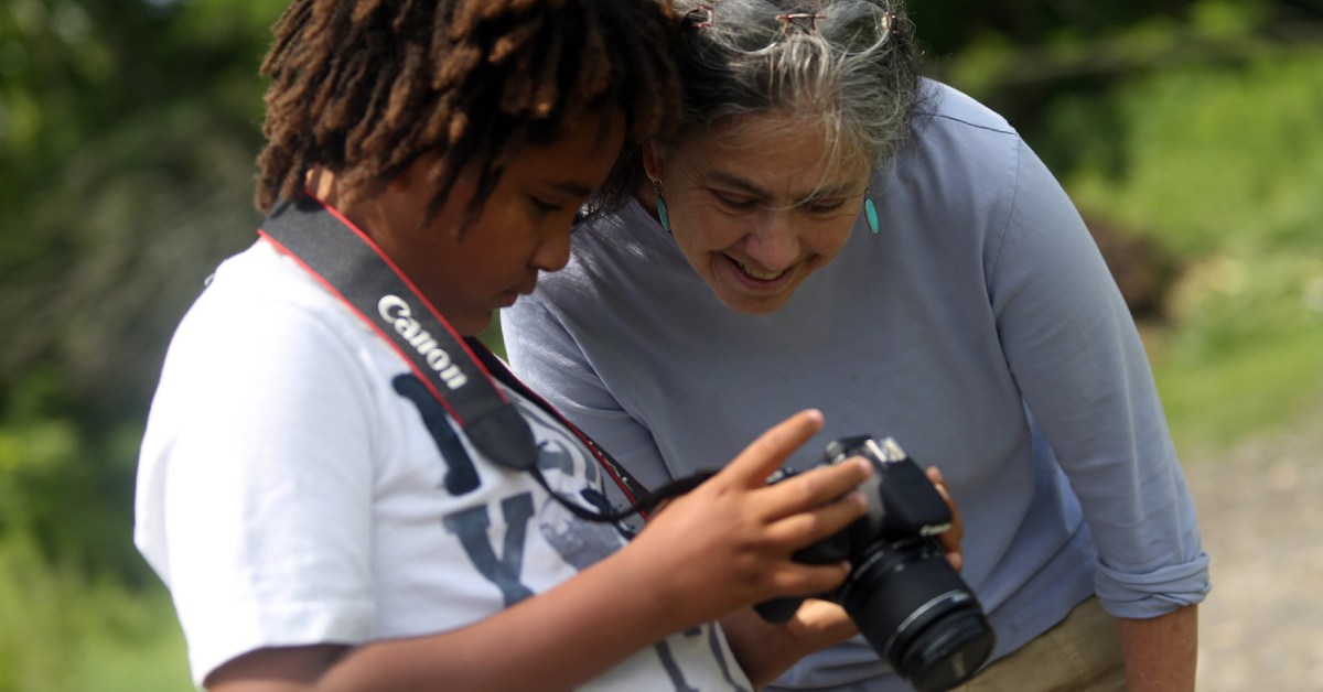 boy showing instructor something on a camera