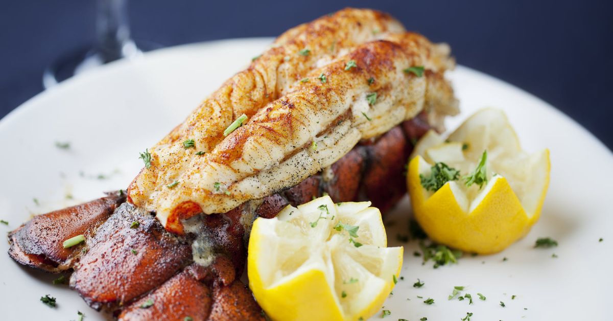 cooked lobster tail plated with lemons