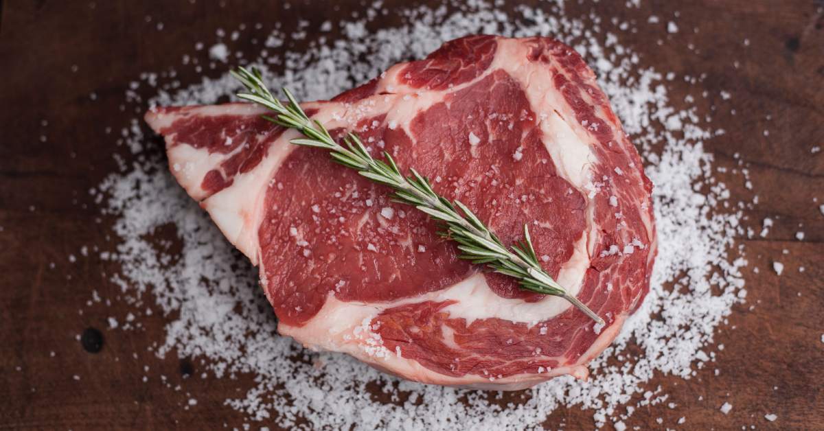 raw steak with salt and rosemary