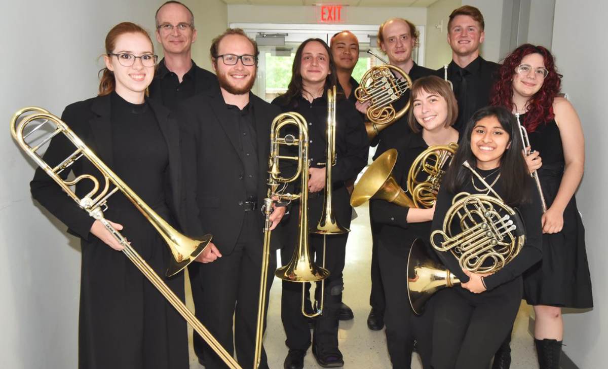 group of musicians wearing black and holding brass instruments