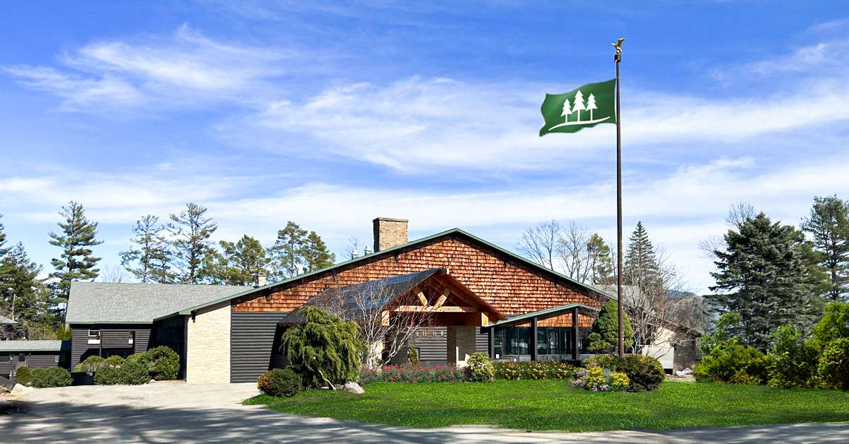 lodge with green flag with three pine trees on it