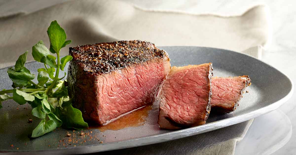 rare steak cut open on grey plate