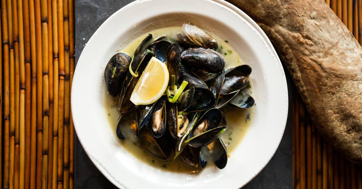 plate of mussels with loaf of bread on the side