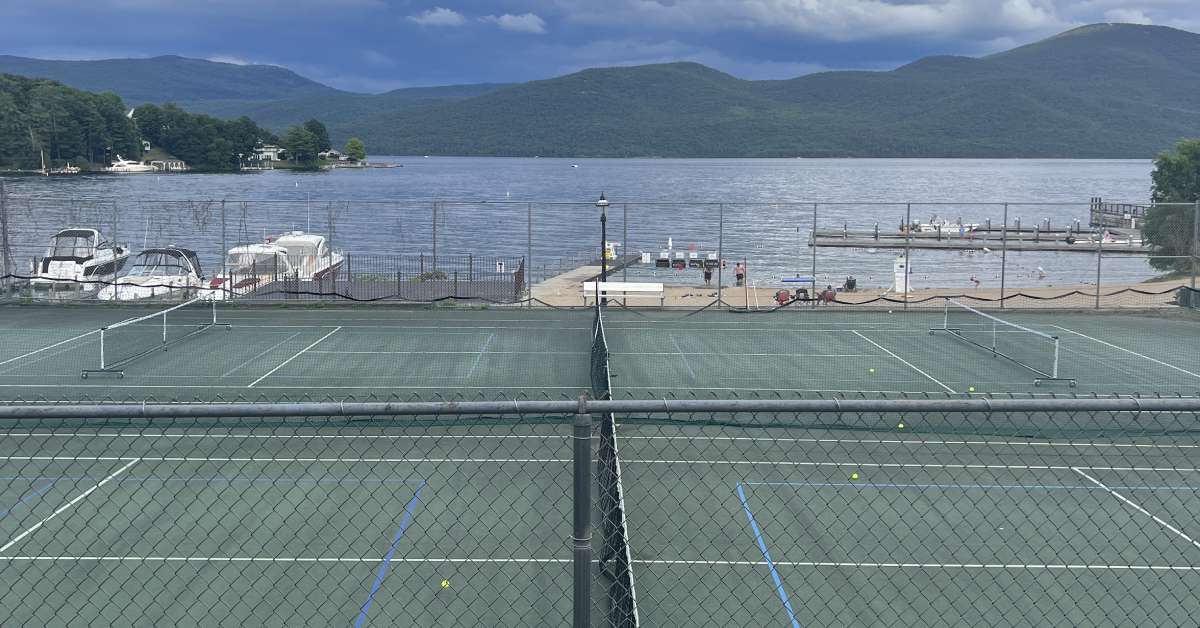 tennis courts with the lake and mountains in the background