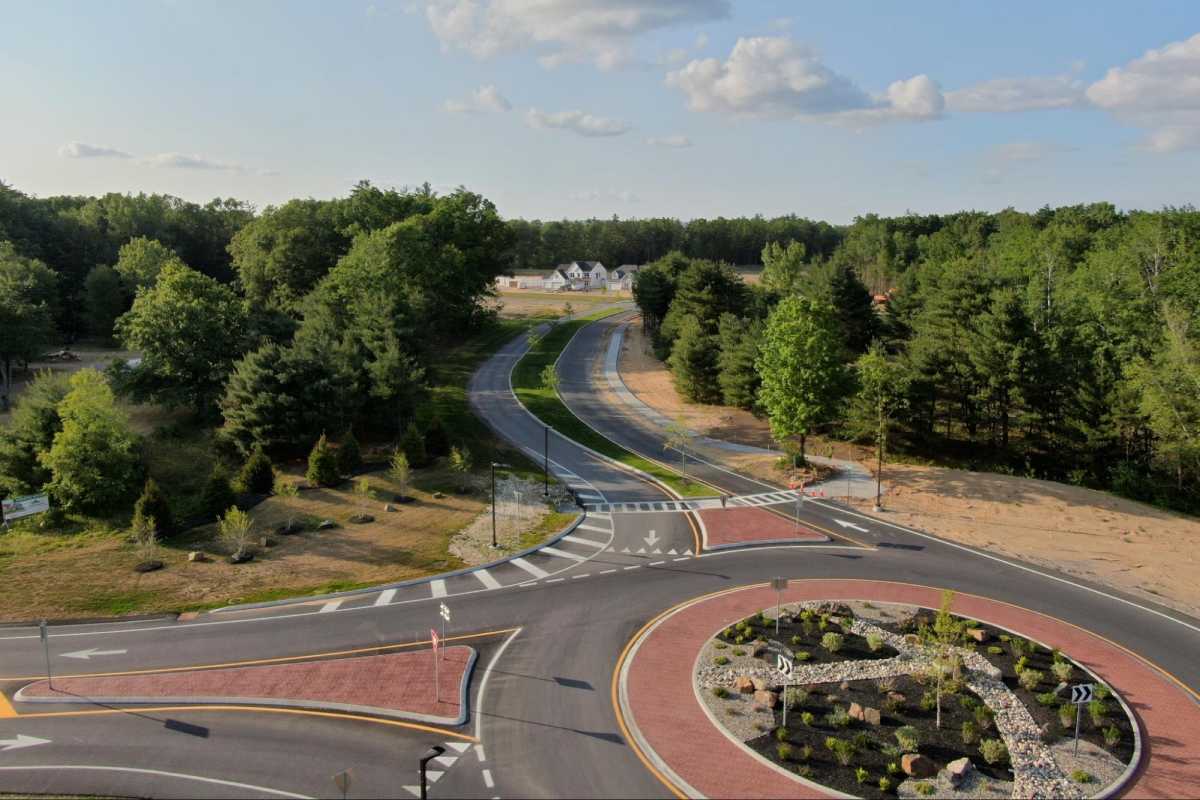 a traffic circle with road leading into a new home community