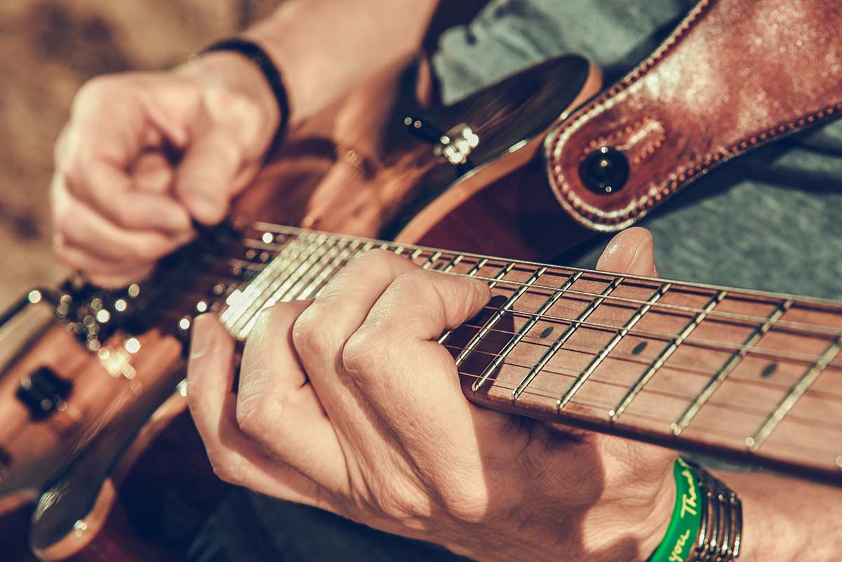 Caucasian male playing guitar