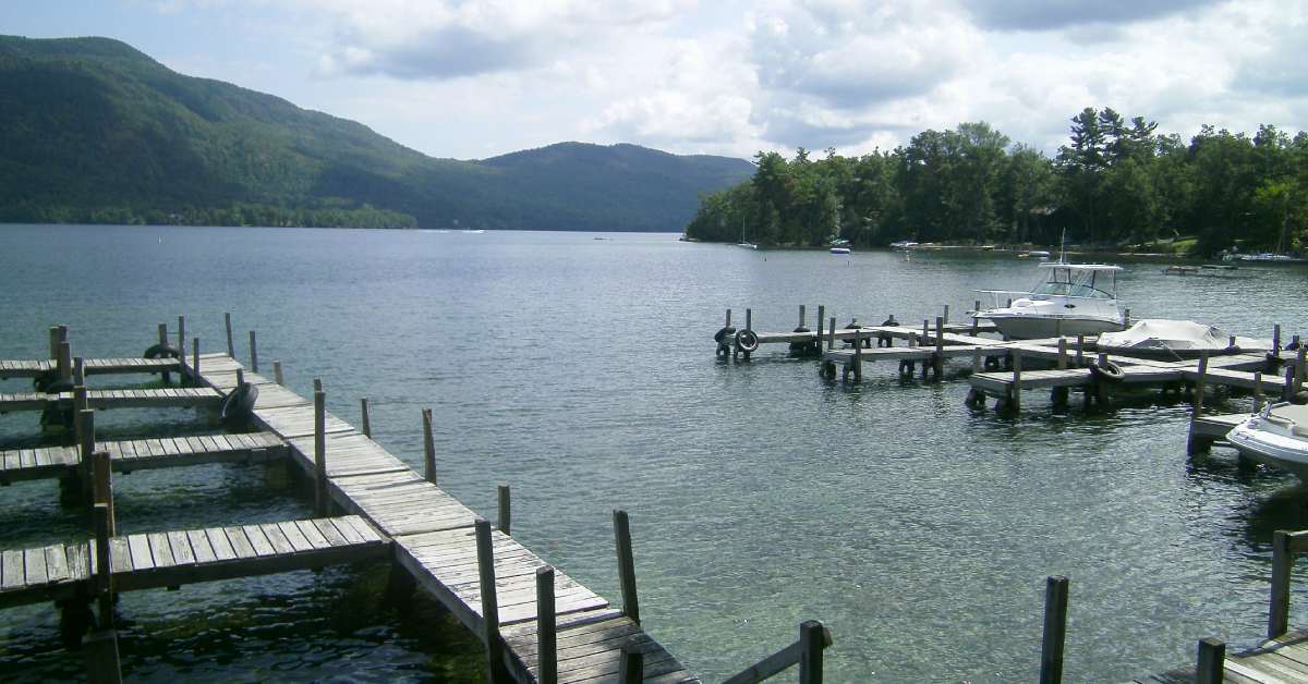 long boat docks on a lake with mountains in the background