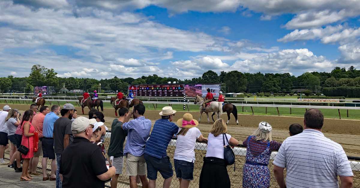 people by the fence at a horse racing track