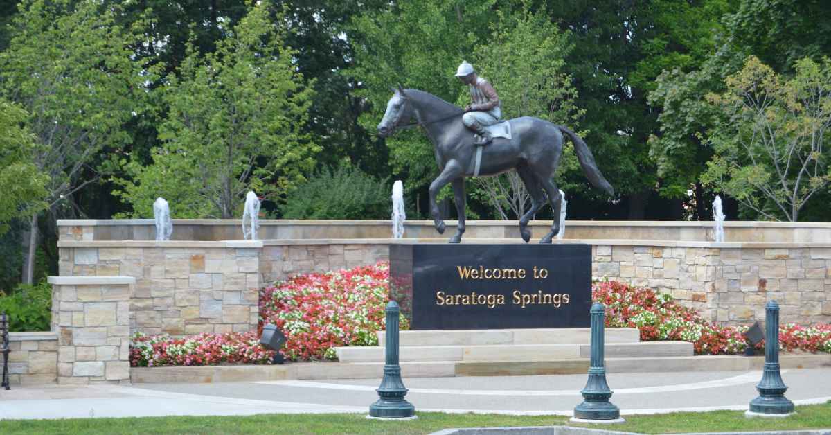 a horse racing statue and words that read welcome to saratoga springs