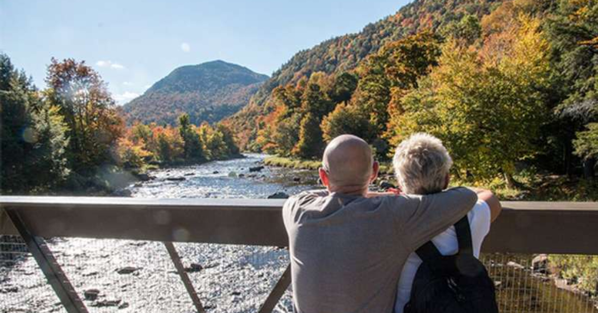 couple looking over a river with mountains in the background