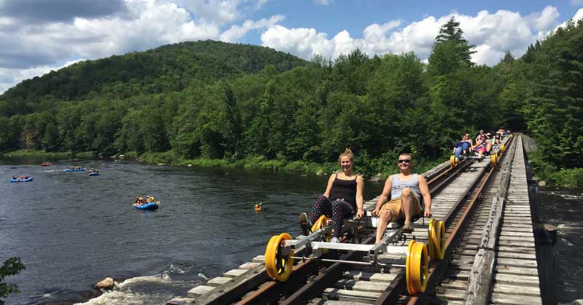 people rail biking over a river