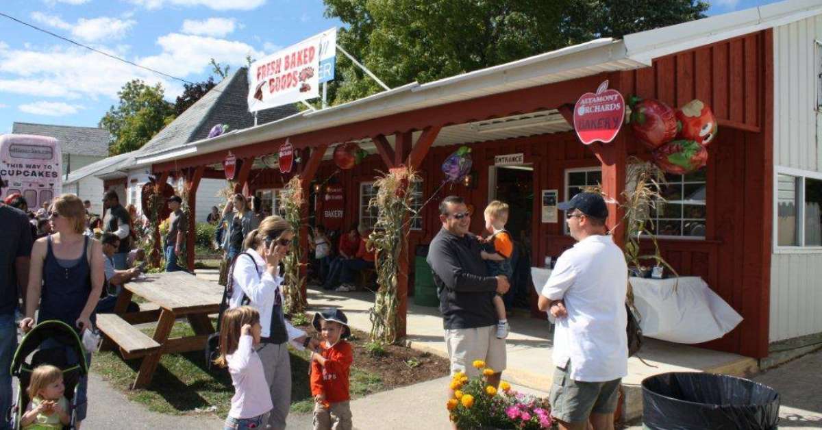 group of people with kids outside of a red and white building