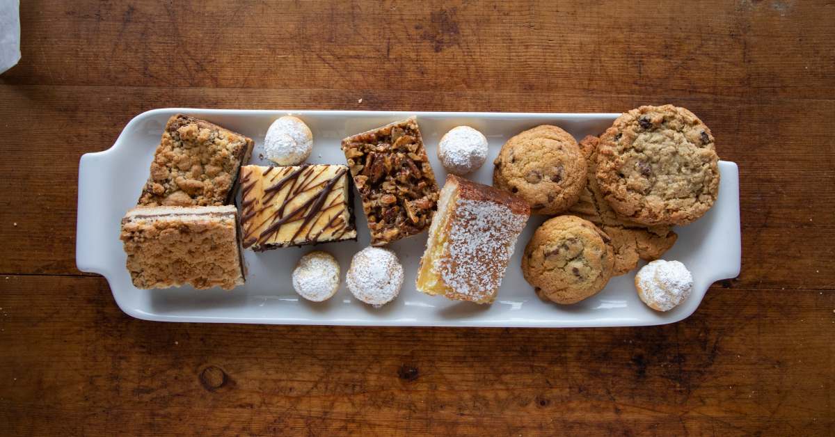a plate with coffee cake, cookies, and other desserts on it