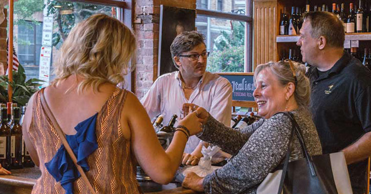 people at an indoor wine tasting in a wine store