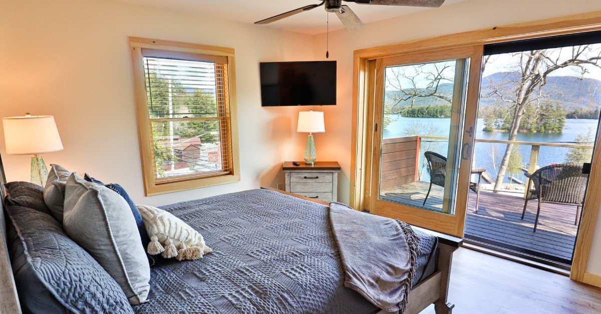 a cozy bedroom with a patio overlooking a lake