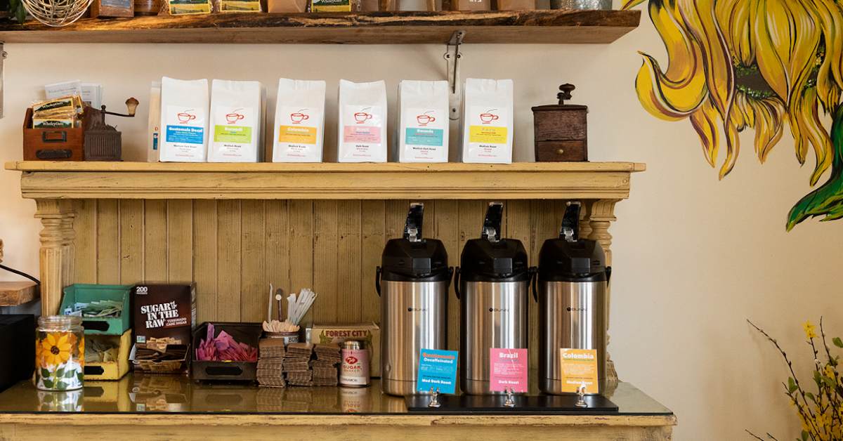 coffee bar display with coffee bags, thermoses, and sugar