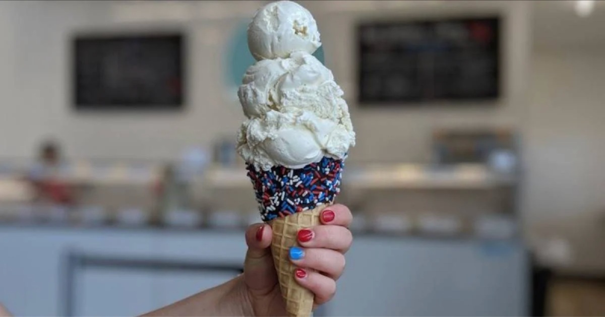 someone holding an ice cream cone with white ice cream