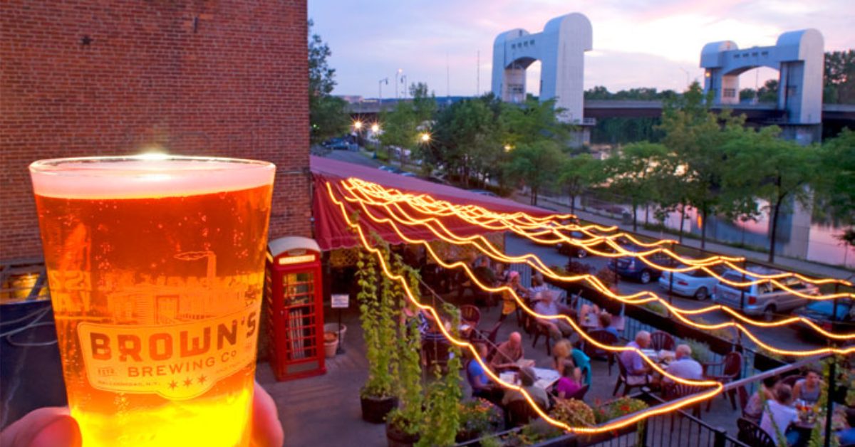 close up of a glass of beer overlooking a patio on the water