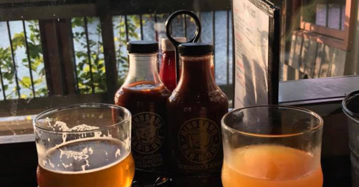 two glasses of beer on a table overlooking water