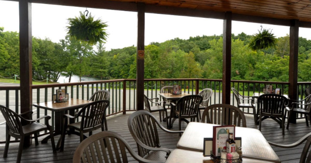 restaurant patio with tables and chairs overlooking water