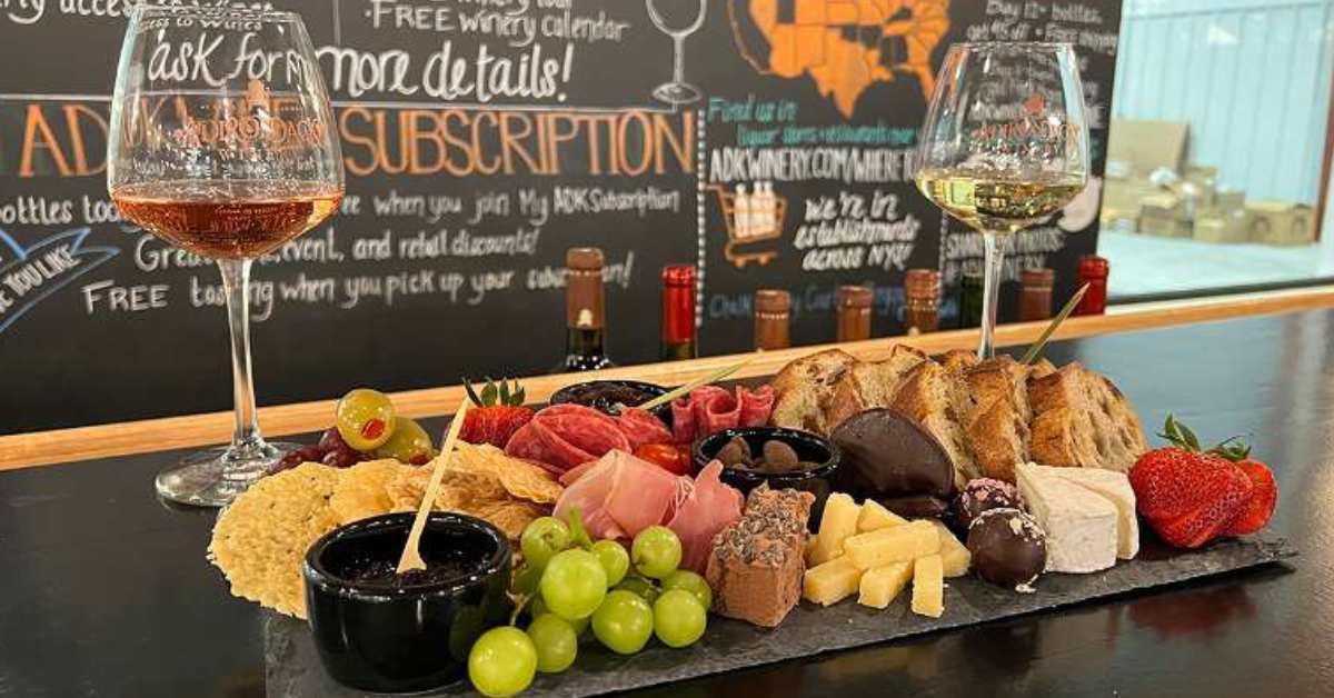 wine glasses and cheese and fruit board