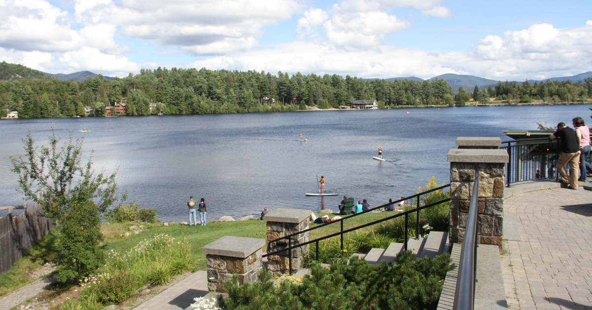 a park overlooking a lake with people on SUPs