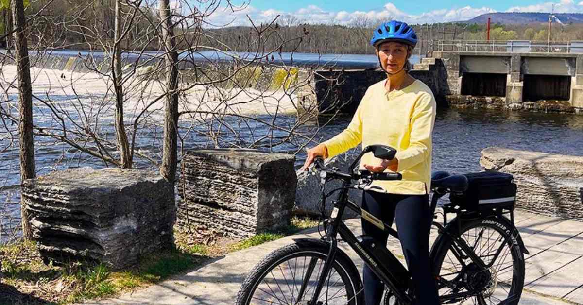 woman on a bike in front of a waterfall