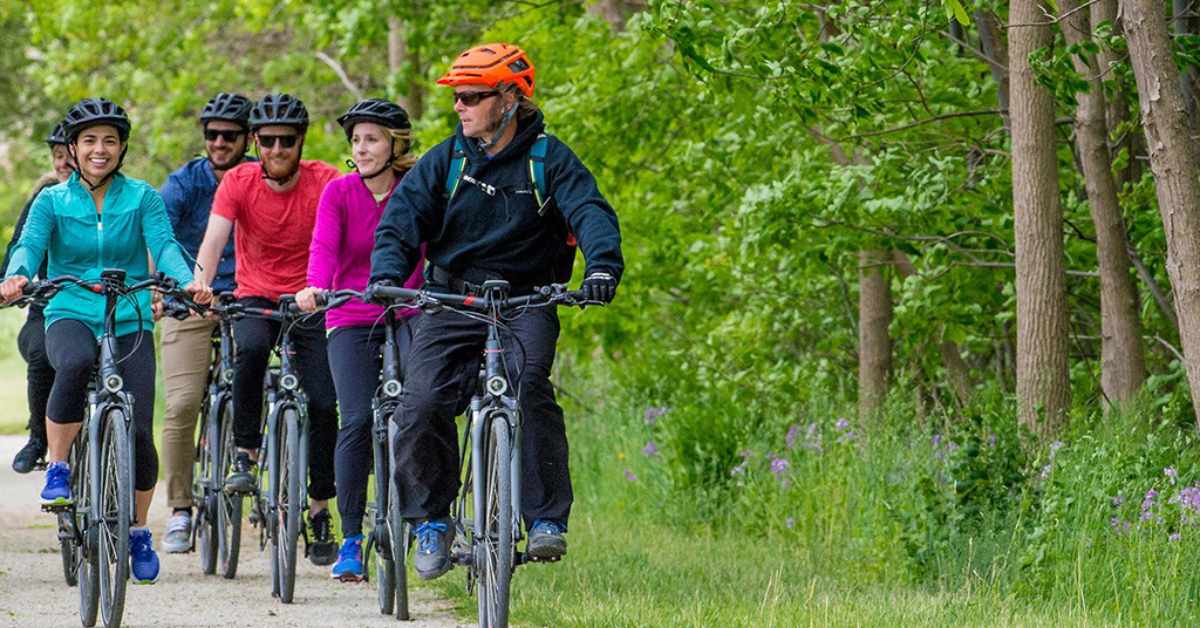 group of people riding bikes on a path