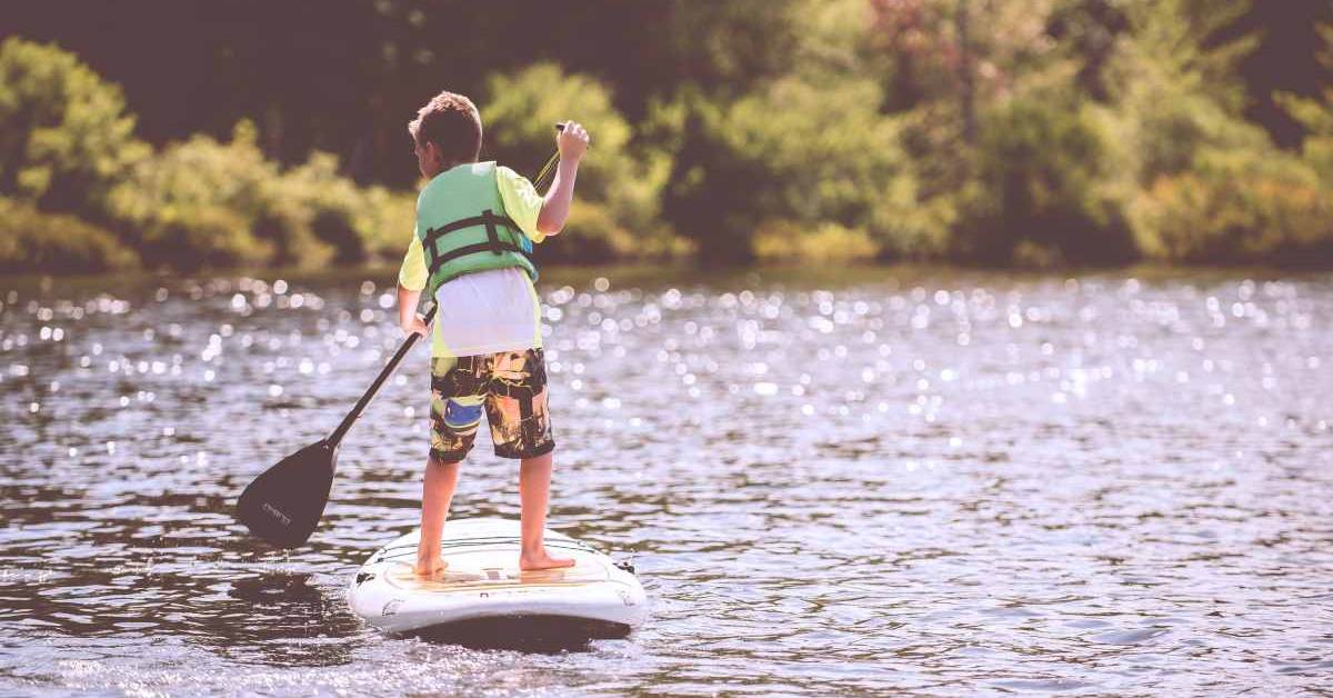 boy paddling on stand up paddleboard