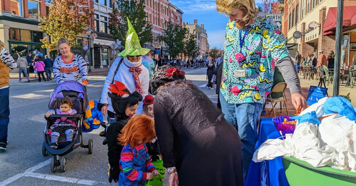 kids in costumes trick or treat at city halloween event
