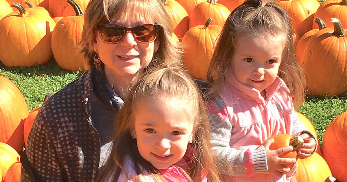 woman and two girls with pumpkins