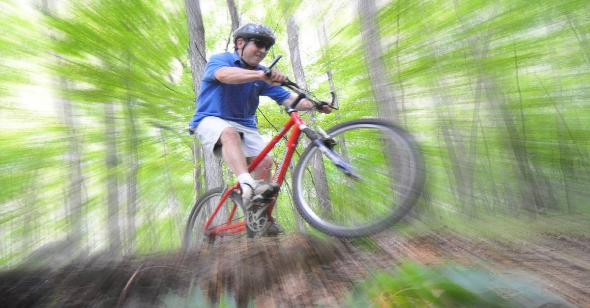 man bikes in the woods