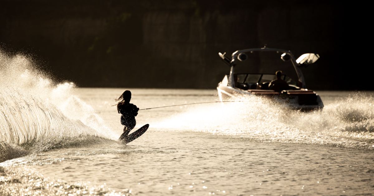 silhouette of a person waterskiing behind a boat