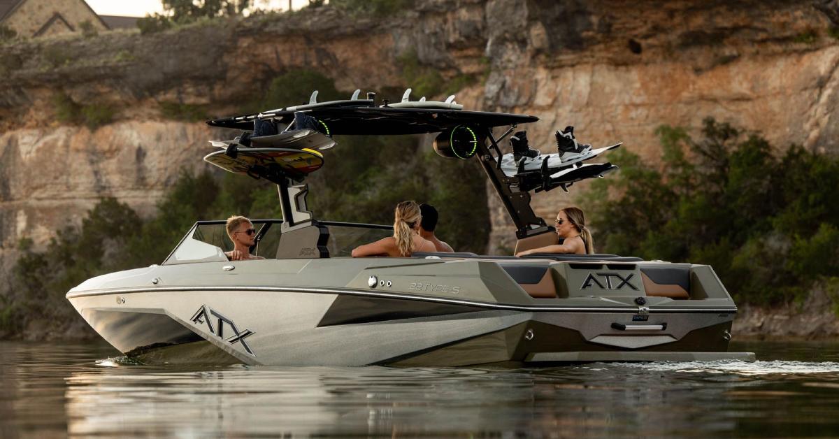 four people sitting on an ATX boat in the water