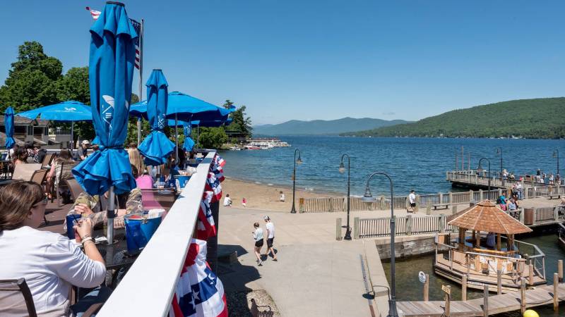 people on deck of restaurant with view of beach