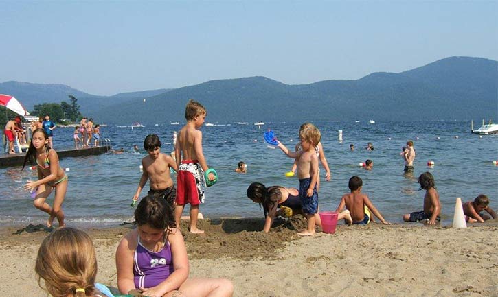 kids playing on a Bolton Landing beach