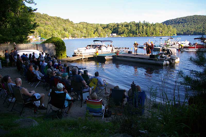 Musicians play from a dock on Caroga Lake during the Caroga Lake Music Festival