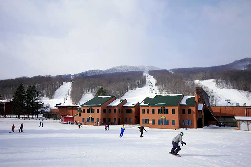 Skiiers and snowboarders descend Gore Mountain