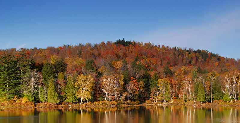 Fall foliage reflecting on Lake Clear in the Adirondacks