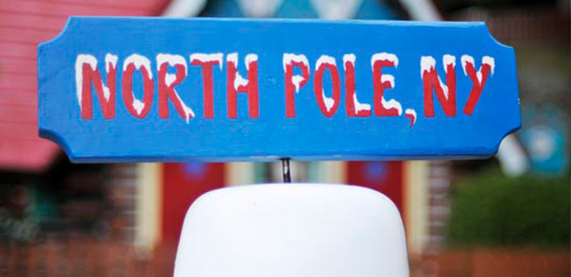 Blue sign that North Pole NY in red lettering displayed at Santa's Workshop