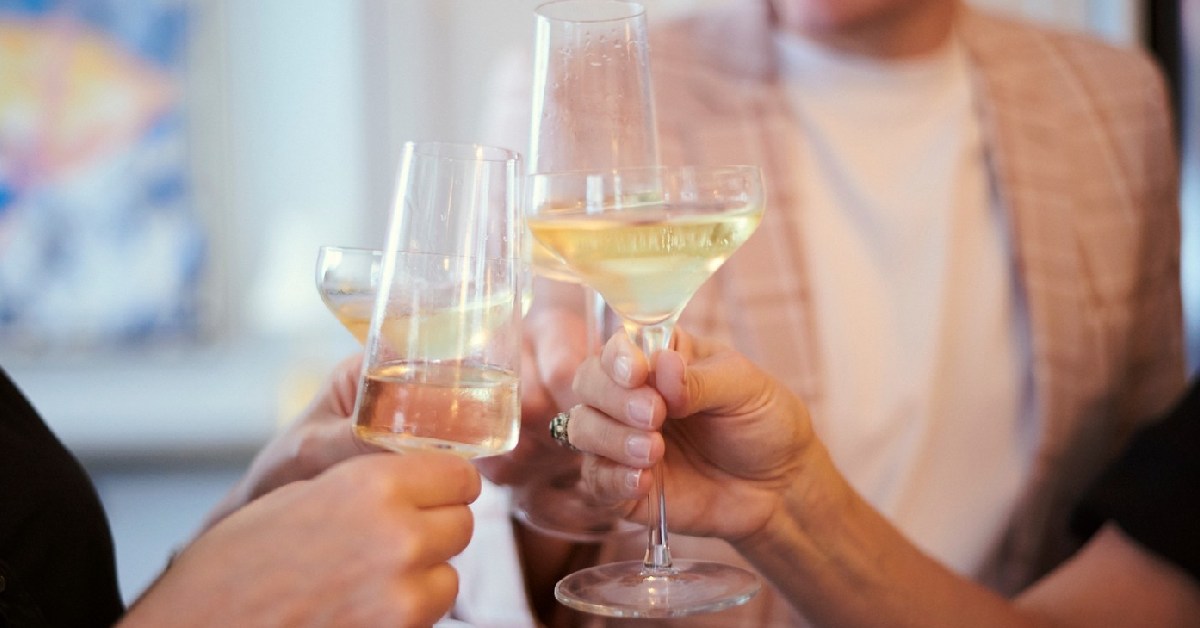 four people toasting with wine glasses